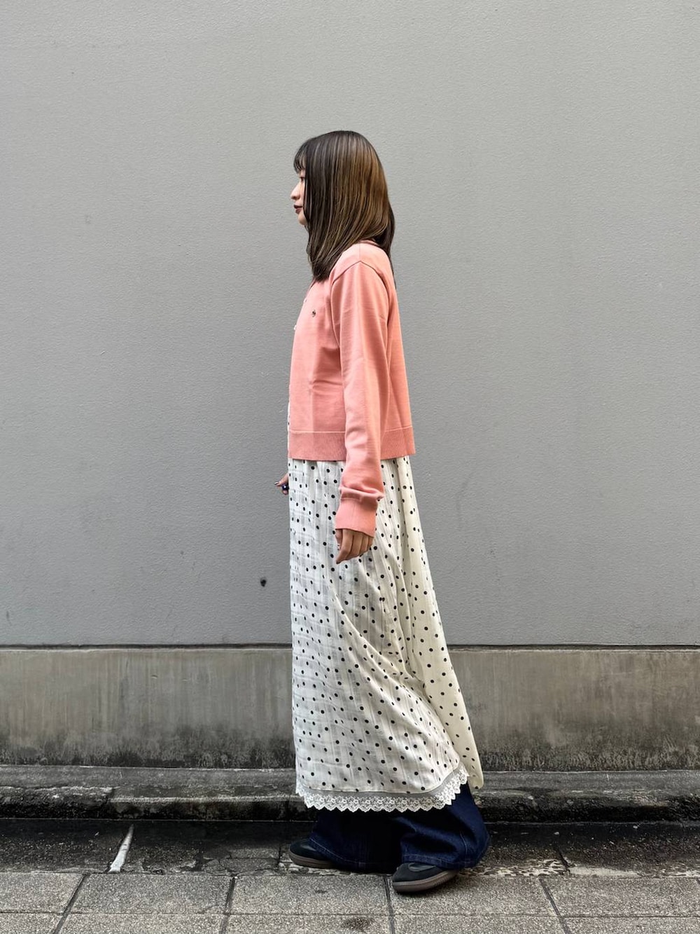 ブルー系のデニムパンツ、ホワイト系のワンピース、ピンク系のTシャツ/カットソーを着用したレディースの春コーディネートの4枚目の写真