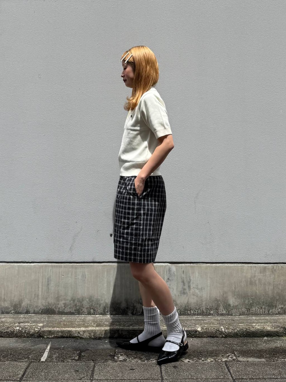 ブラック系のパンプス、ブラック系のその他パンツ、ホワイト系のポロシャツを着用したレディースの春コーディネートの6枚目の写真