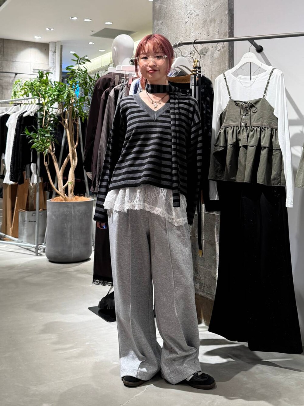 ホワイト系のTシャツ/カットソー、ブラック系のニット/セーター、グレー系のスウェットパンツを着用したレディースの秋コーディネートの2枚目の写真