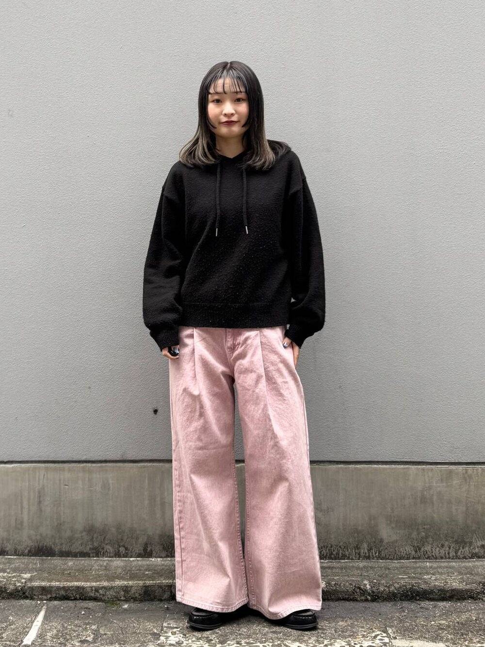 ピンク系のデニムパンツ、ブラック系のニット/セーターを着用したレディースの春コーディネートの3枚目の写真