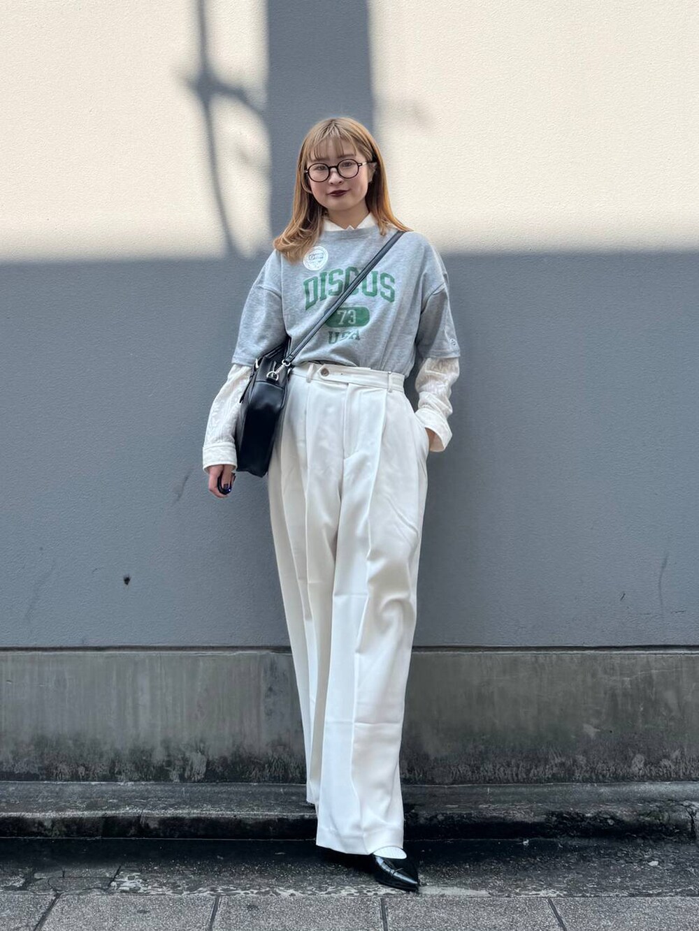 グレー系のTシャツ/カットソー、ブラック系のパンプス、ホワイト系のシャツ/ブラウスを着用したレディースの春コーディネートの3枚目の写真