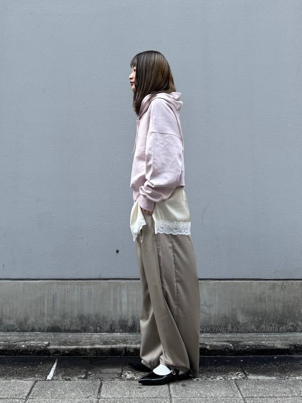 ブラック系のパンプス、ホワイト系のキャミソール、ベージュ系のスラックスを着用したレディースの春コーディネートの5枚目の写真