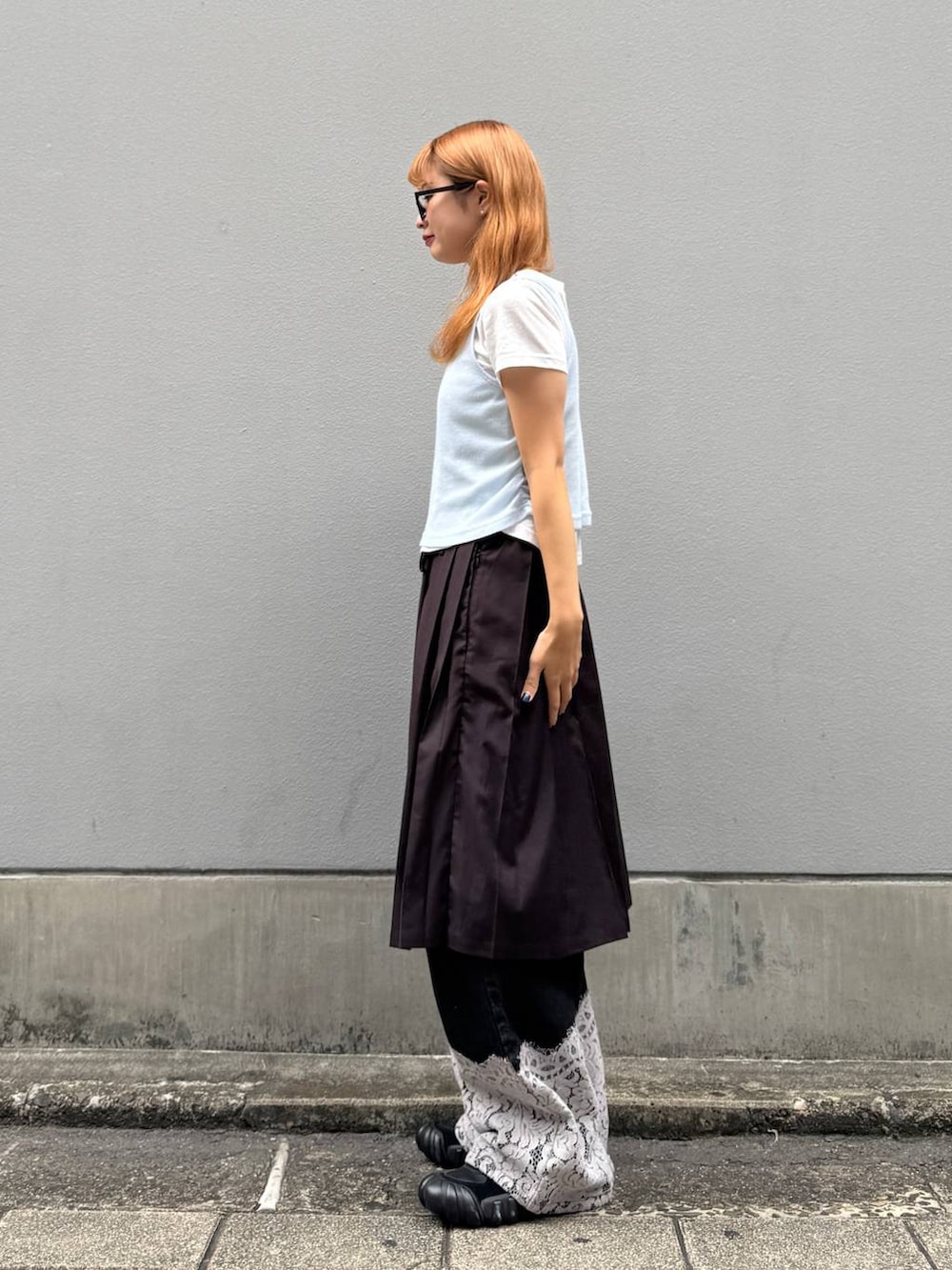 ブラウン系のスカート、ブラック系のデニムパンツ、ホワイト系のTシャツ/カットソーを着用したレディースの秋コーディネートの6枚目の写真