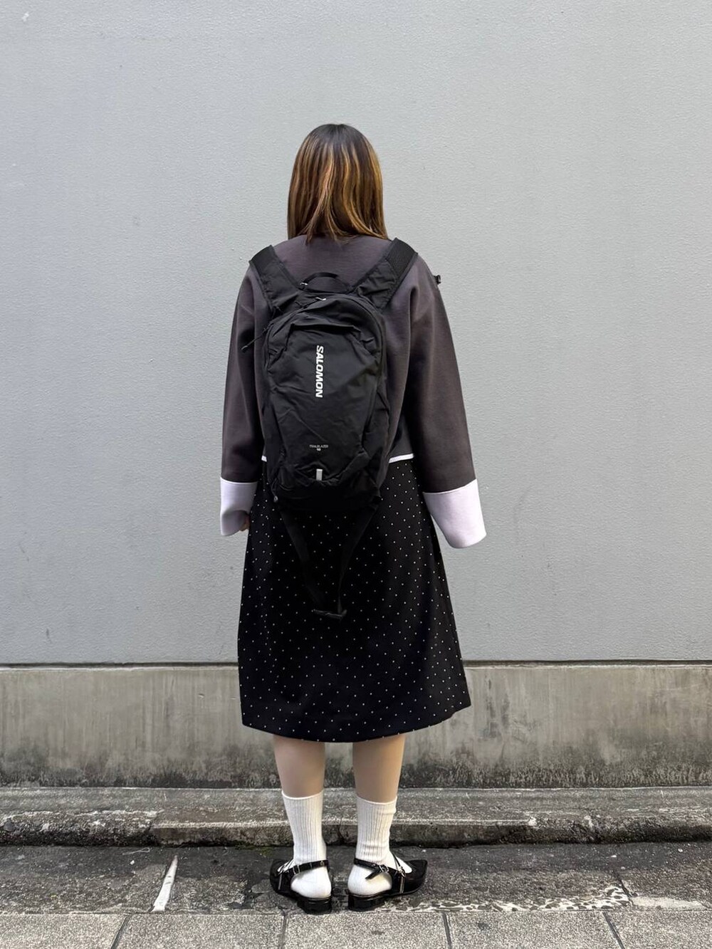 ブラック系のパンプス、グレー系のカーディガン/ボレロ、ブラック系のワンピースを着用したレディースの春コーディネートの6枚目の写真