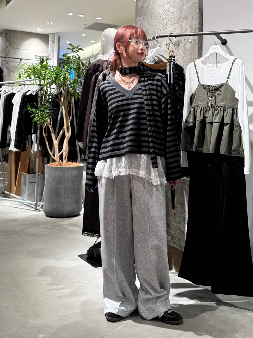 ホワイト系のTシャツ/カットソー、ブラック系のニット/セーター、グレー系のスウェットパンツを着用したレディースの秋コーディネートの4枚目の写真