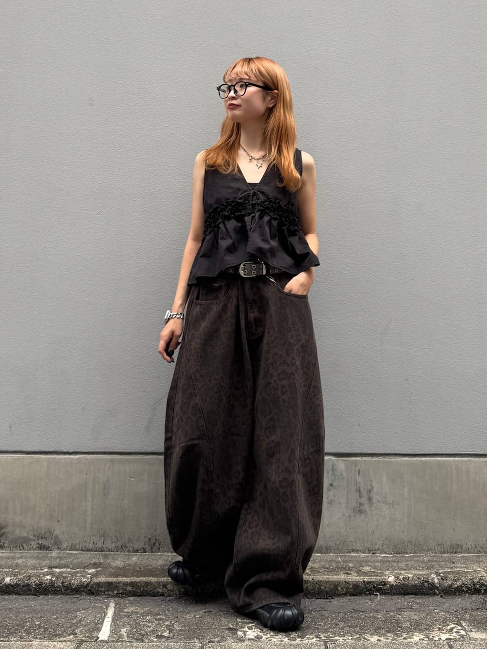 ブラウン系のデニムパンツ、ブラック系のベスト、ブラック系のベルトを着用したレディースの夏コーディネートの2枚目の写真