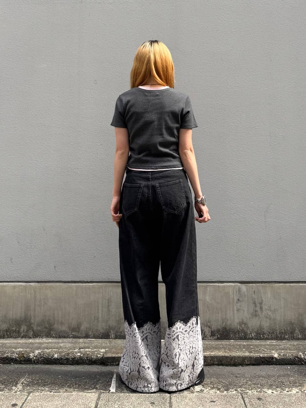 ブラック系のデニムパンツ、グレー系のTシャツ/カットソー、ブラック系のベルトを着用したレディースの夏コーディネートの6枚目の写真