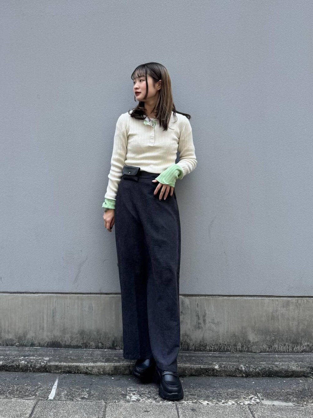 ブラック系のローファー、ブラック系のスカート、ホワイト系のニット/セーターを着用したレディースの春コーディネートの2枚目の写真