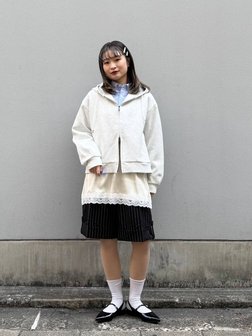ブルー系のシャツ/ブラウス、ブラック系のパンプス、ホワイト系のパーカーを着用したレディースの春コーディネートの4枚目の写真