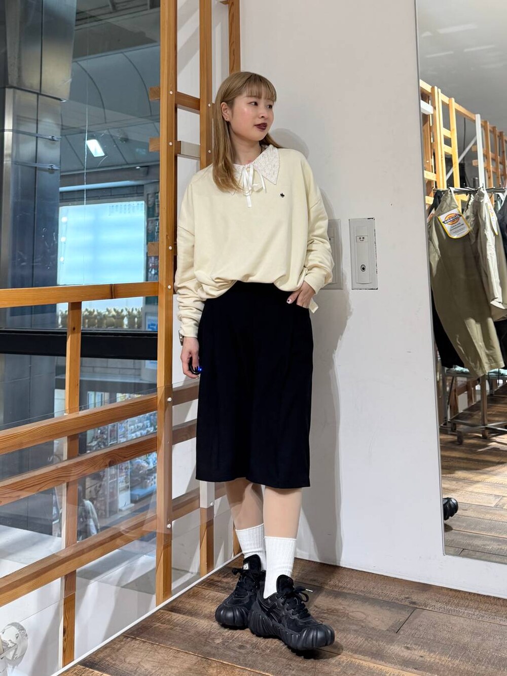 ホワイト系のスウェット、ブラック系のスラックスを着用したレディースの春コーディネートの4枚目の写真