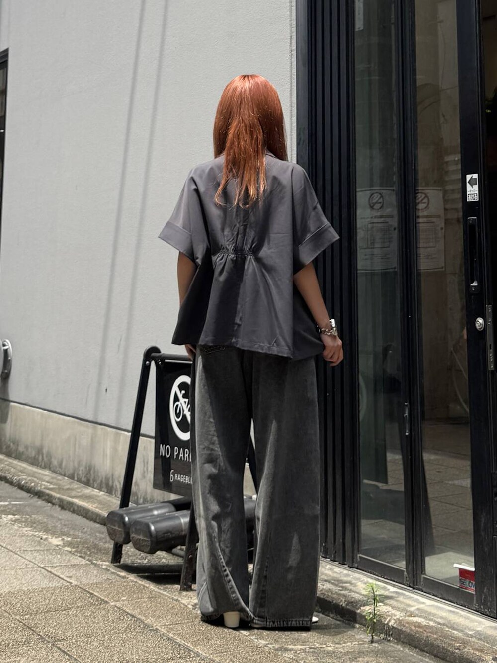 グレー系のデニムパンツ、グレー系のテーラードジャケット、ホワイト系のキャミソールを着用したレディースの夏コーディネートの5枚目の写真