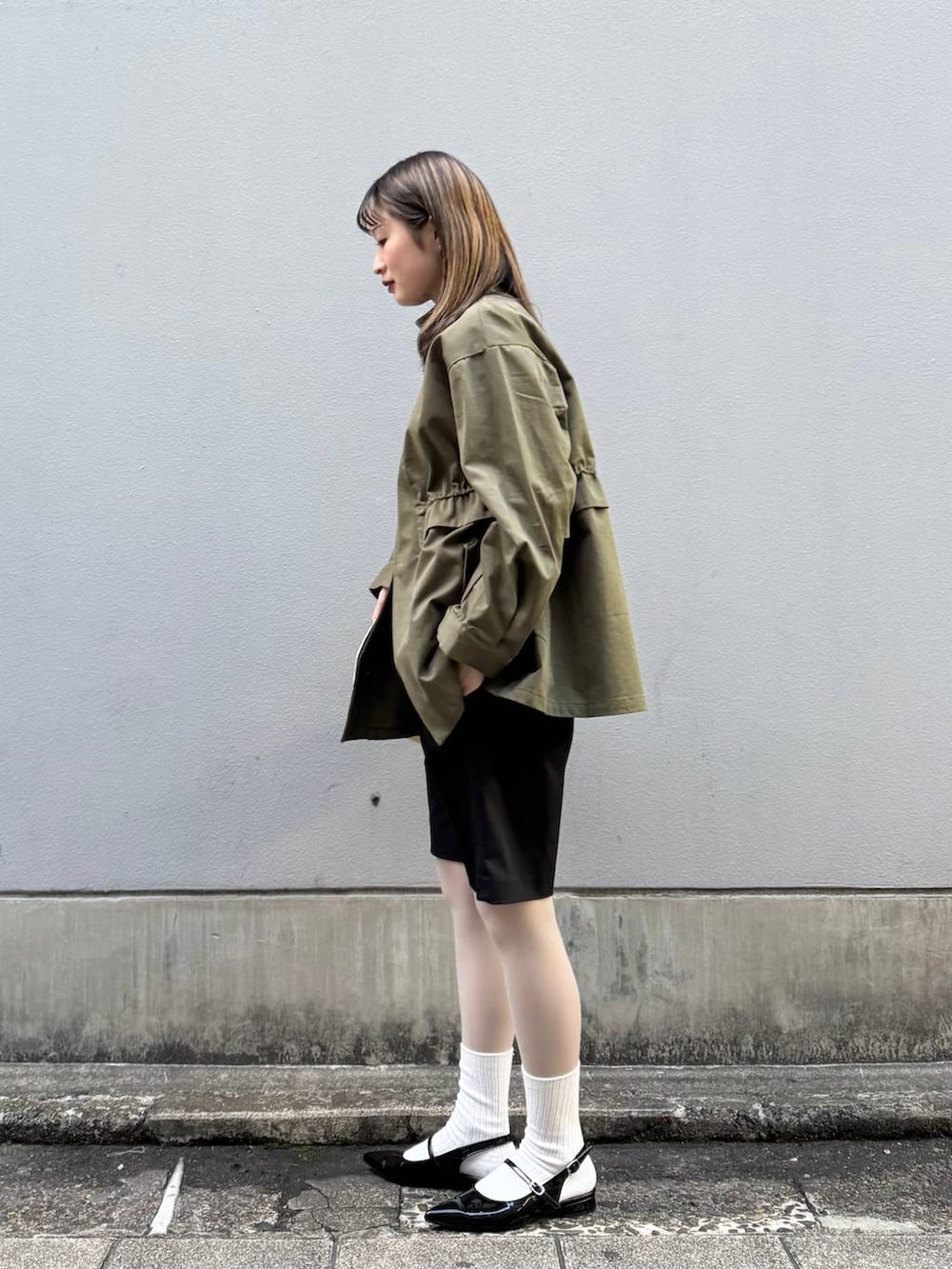 ブラック系のパンプス、ブラック系のスラックス、イエロー系のショルダーバッグを着用したレディースの春コーディネートの4枚目の写真