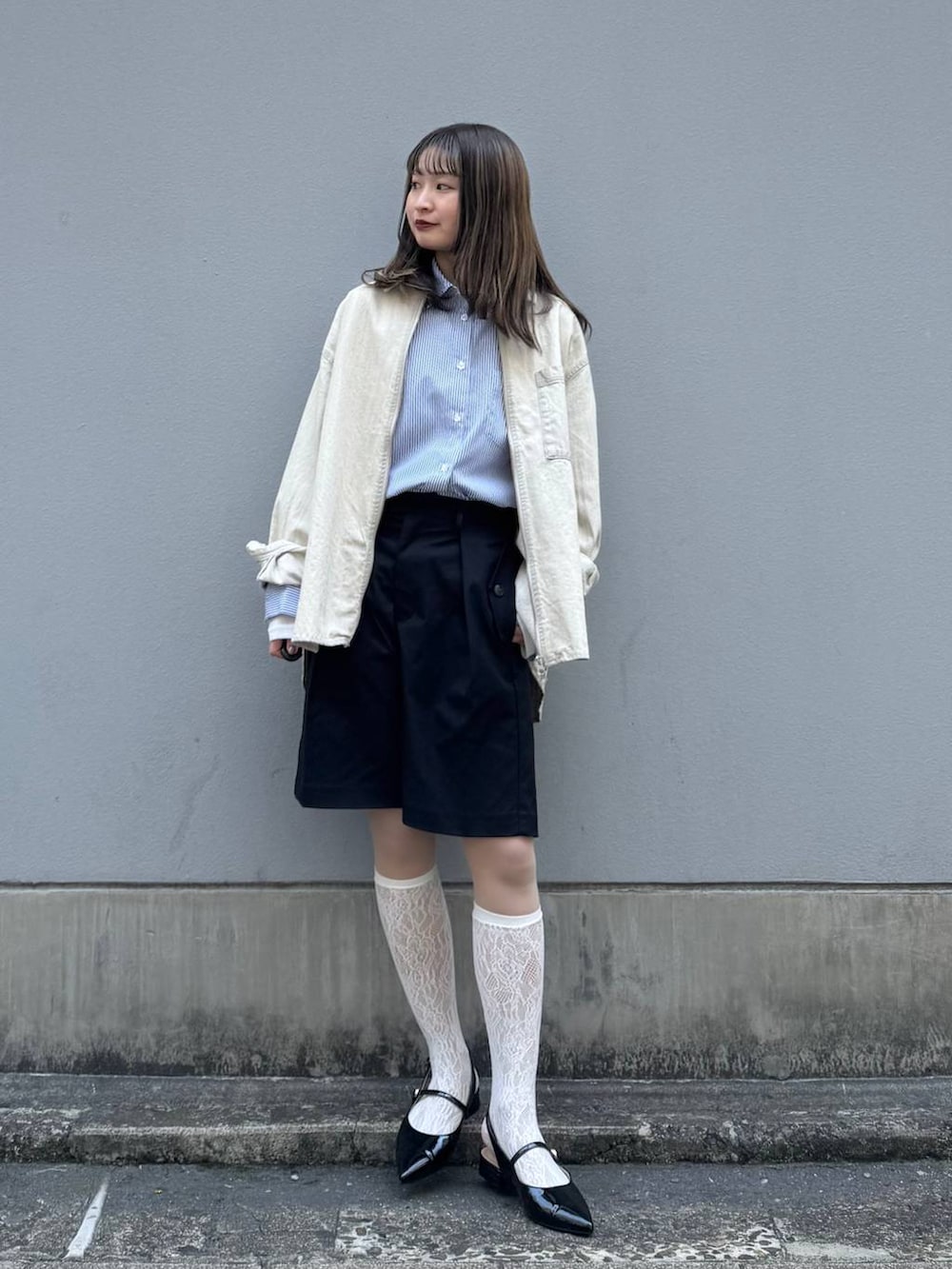 ブラック系のパンプス、ブラック系のスラックス、ブルー系のシャツ/ブラウスを着用したレディースの春コーディネートの2枚目の写真