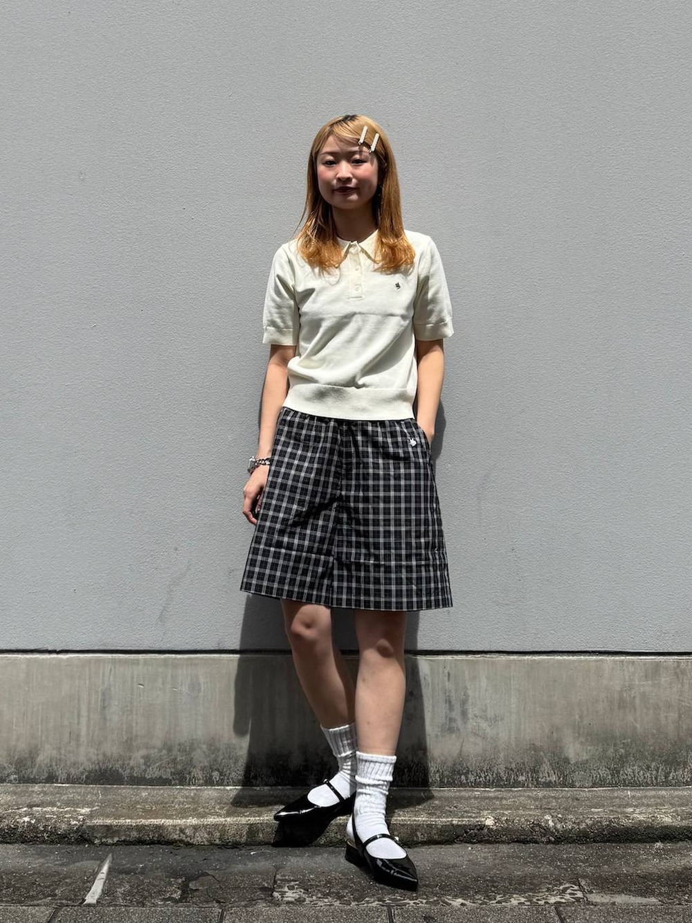 ブラック系のパンプス、ブラック系のその他パンツ、ホワイト系のポロシャツを着用したレディースの春コーディネートの5枚目の写真