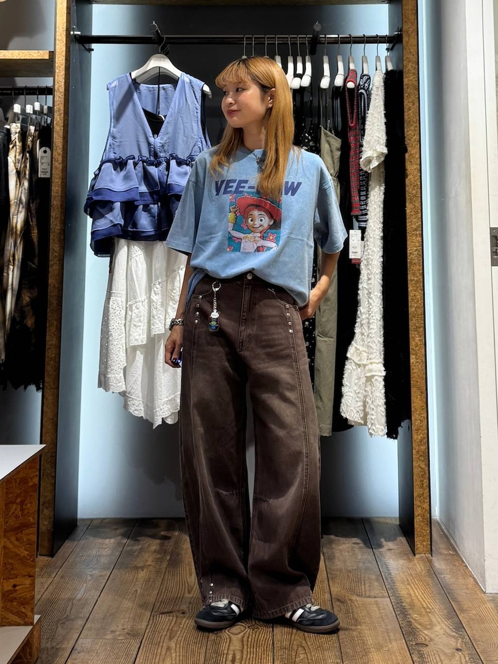 ブルー系のTシャツ/カットソー、ブラウン系のデニムパンツ、その他のキーホルダーを着用したレディースの夏コーディネートの2枚目の写真