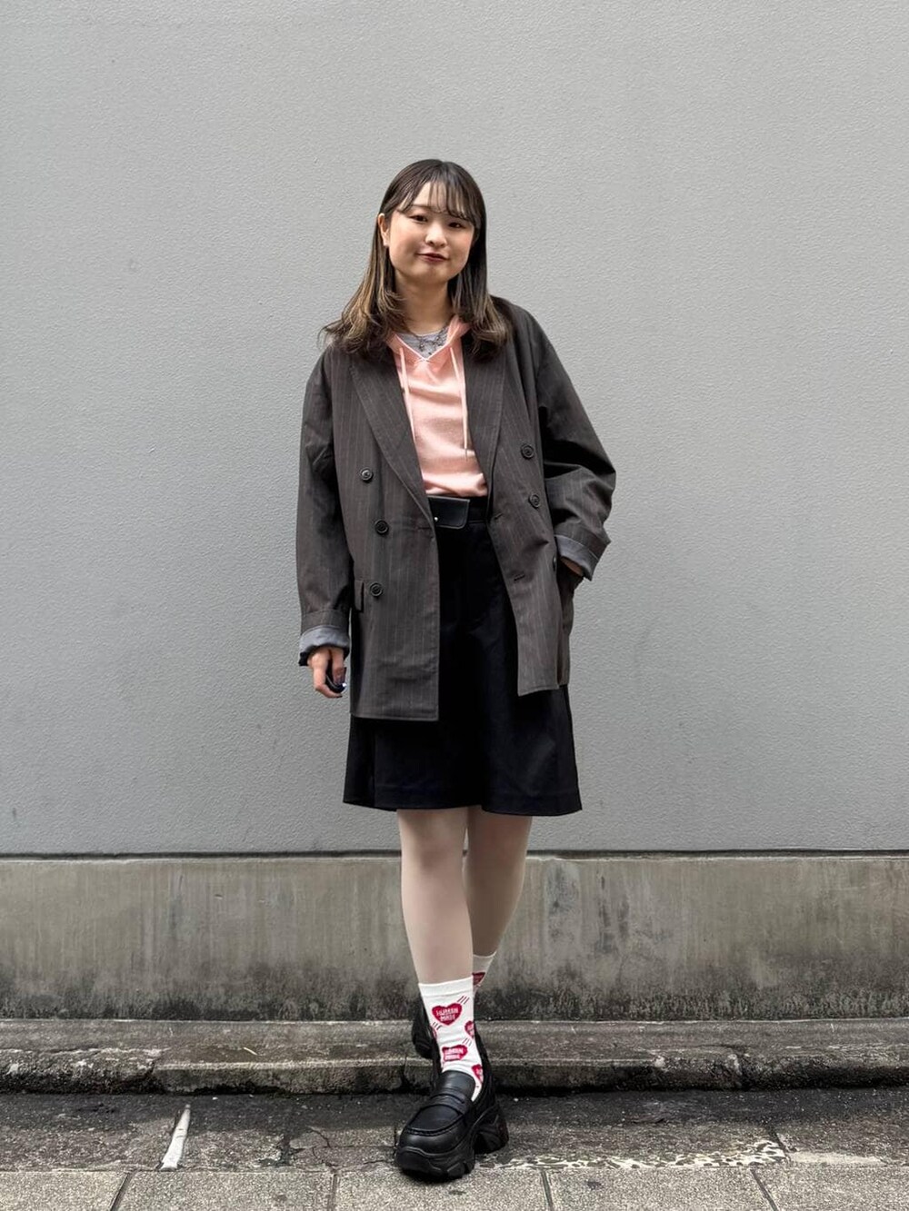 ブラック系のテーラードジャケット、ブラック系のローファー、ブラック系のスラックスを着用したレディースの春コーディネートの4枚目の写真