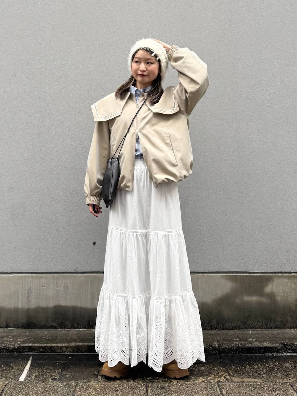 ブラック系のショルダーバッグ、ベージュ系のブルゾン、ブルー系のシャツ/ブラウスを着用したレディースの春コーディネートの2枚目の写真