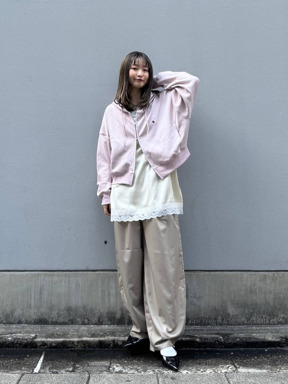 ブラック系のパンプス、ホワイト系のキャミソール、ベージュ系のスラックスを着用したレディースの春コーディネートの4枚目の写真