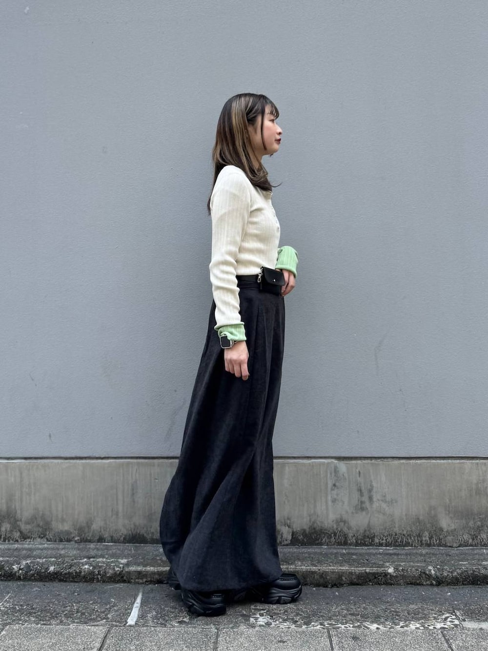 ブラック系のローファー、ブラック系のスカート、ホワイト系のニット/セーターを着用したレディースの春コーディネートの7枚目の写真