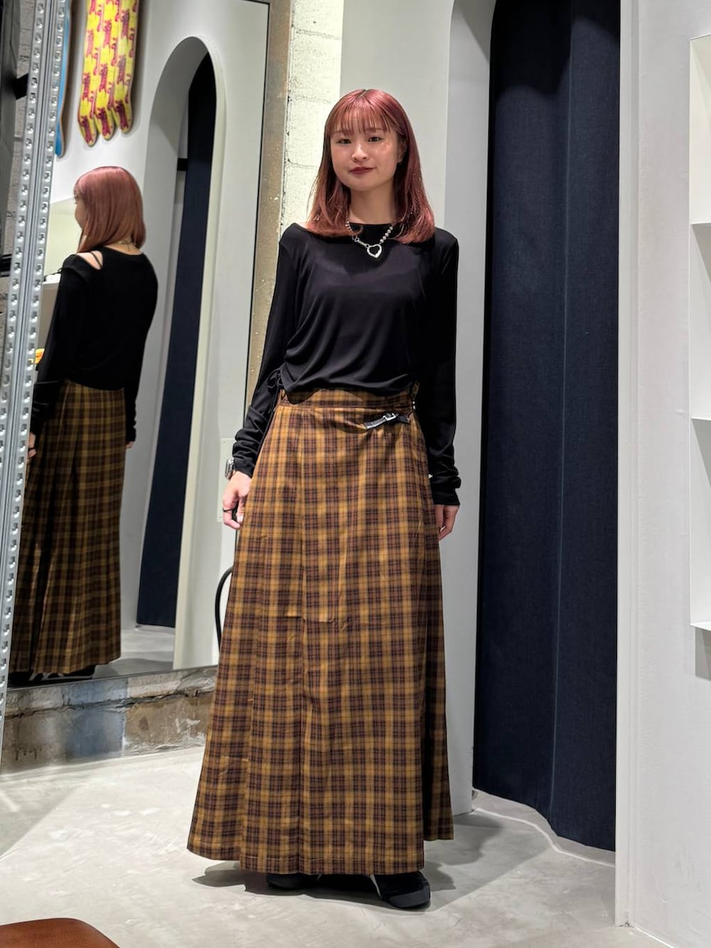 ブラック系のTシャツ/カットソー、イエロー系のスカートを着用したレディースの秋コーディネートの3枚目の写真