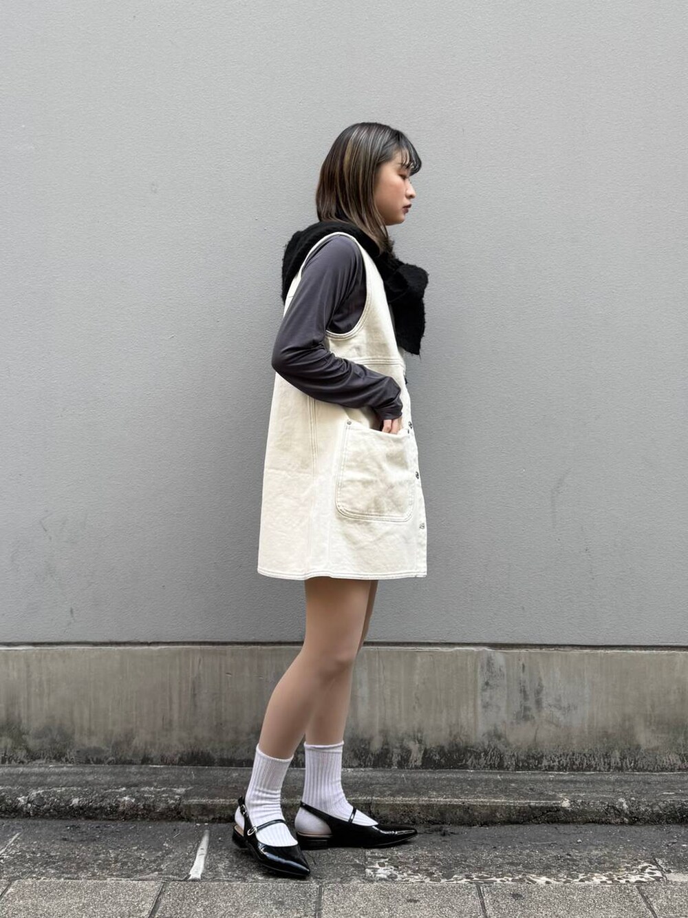 ブラック系のパンプス、ホワイト系のワンピース、グレー系のTシャツ/カットソーを着用したレディースの春コーディネートの7枚目の写真