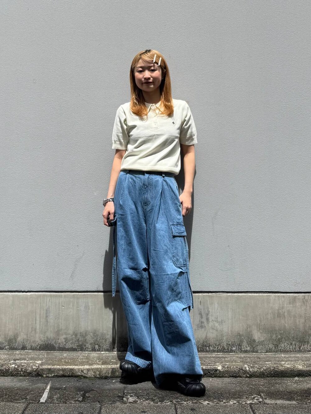ブルー系のデニムパンツ、ホワイト系のポロシャツを着用したレディースの春コーディネートの3枚目の写真