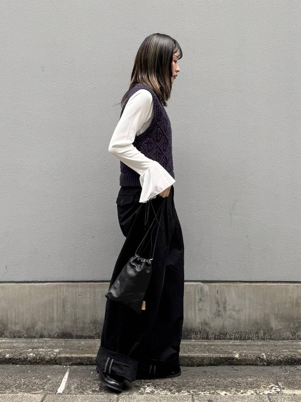 ブラック系のショルダーバッグ、ブラック系のチノパンツ、ホワイト系のTシャツ/カットソーを着用したレディースの春コーディネートの7枚目の写真