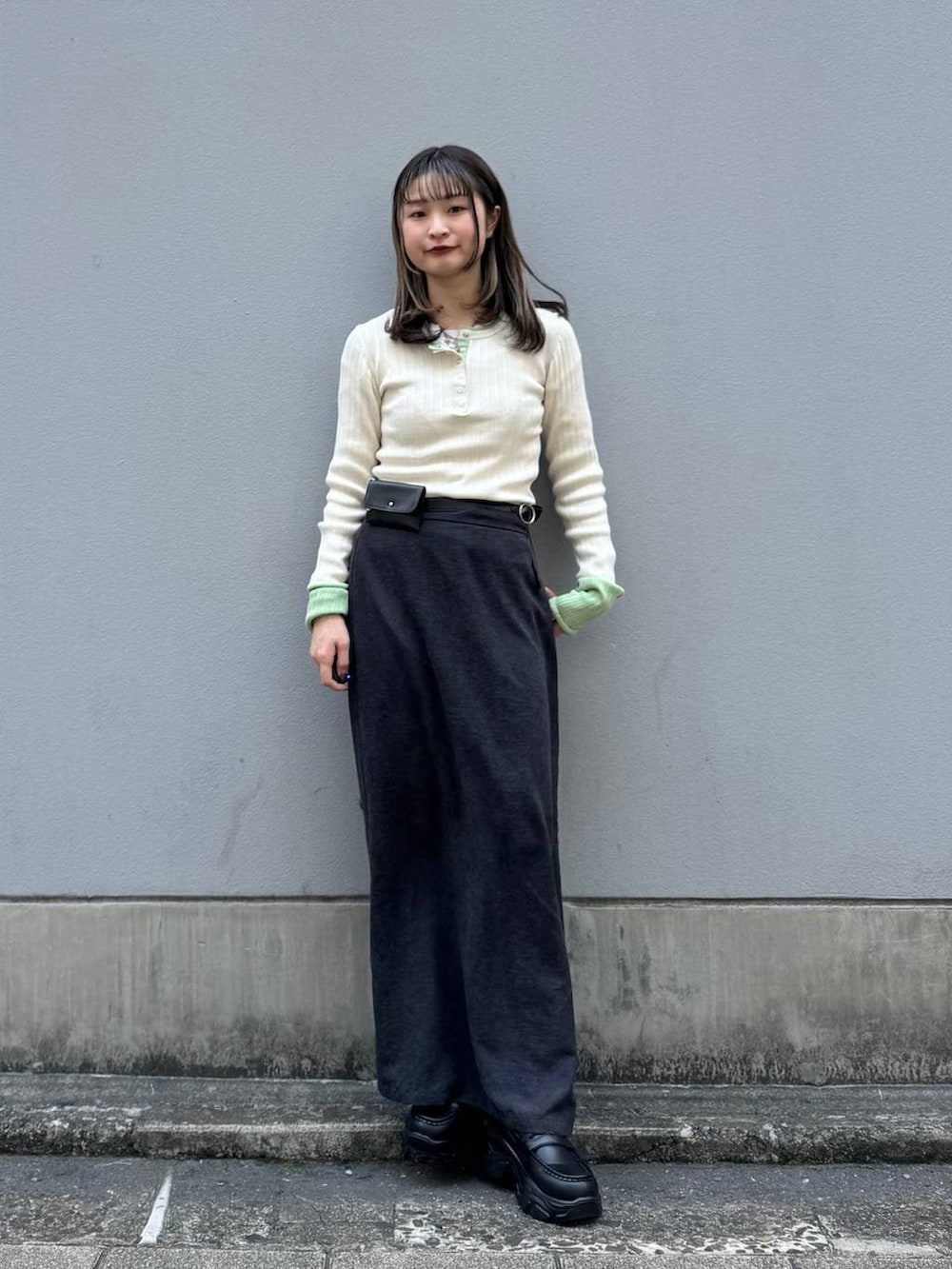 ブラック系のローファー、ブラック系のスカート、ホワイト系のニット/セーターを着用したレディースの春コーディネートの4枚目の写真