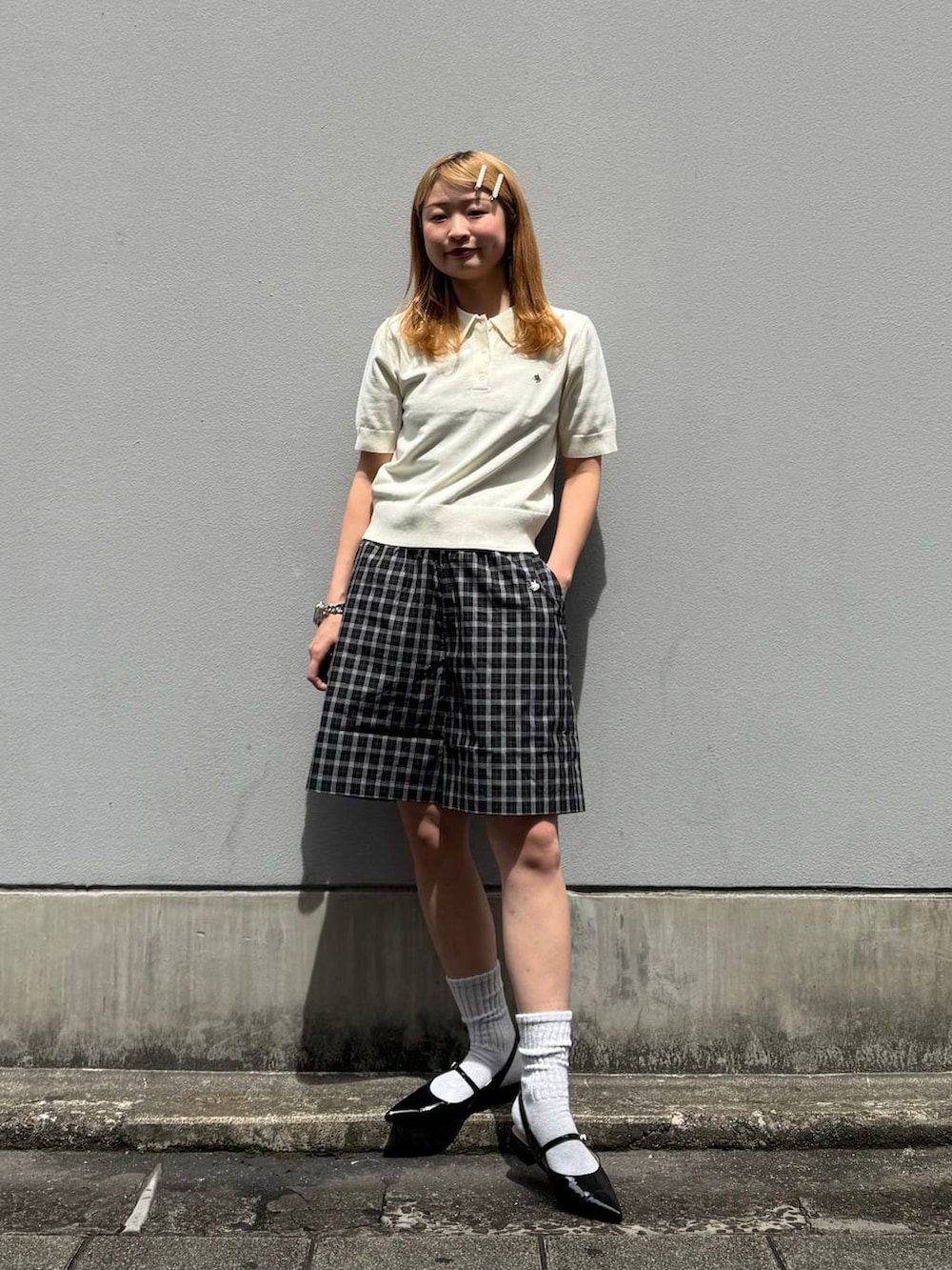 ブラック系のパンプス、ブラック系のその他パンツ、ホワイト系のポロシャツを着用したレディースの春コーディネートの3枚目の写真