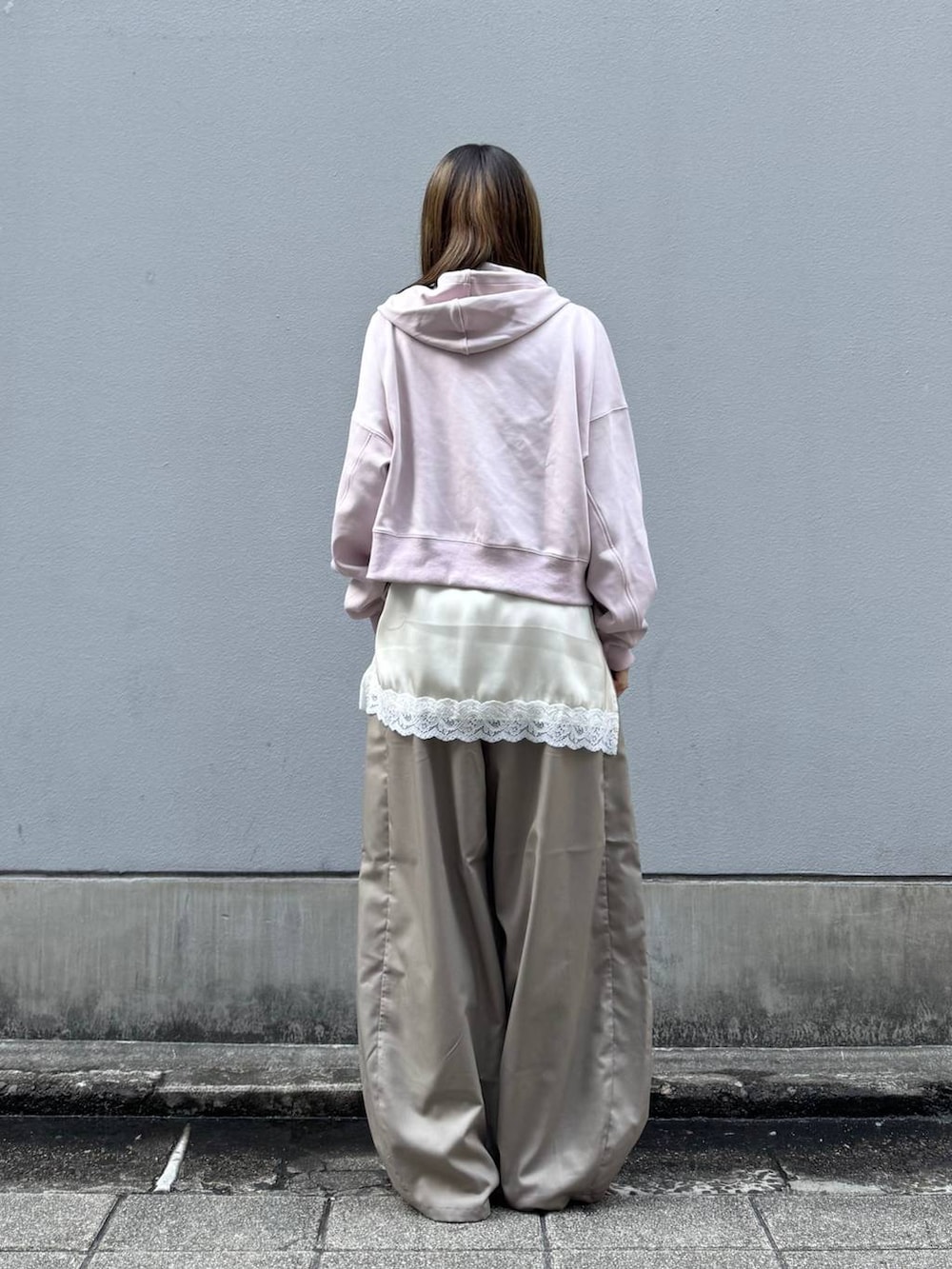 ブラック系のパンプス、ホワイト系のキャミソール、ベージュ系のスラックスを着用したレディースの春コーディネートの6枚目の写真