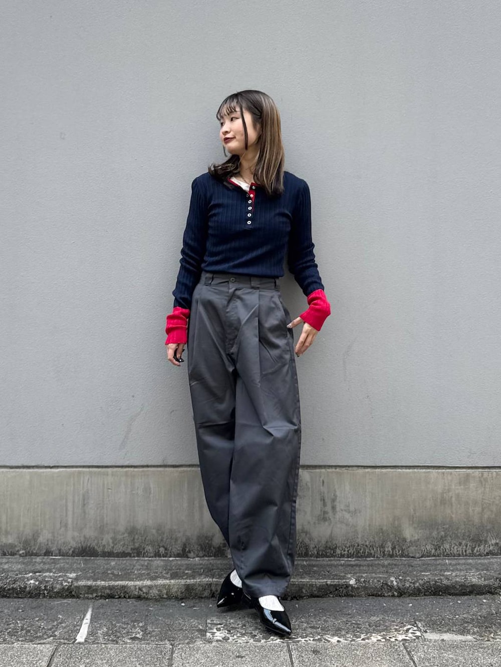 グレー系のチノパンツ、ブラック系のパンプス、ブルー系のニット/セーターを着用したレディースの春コーディネートの2枚目の写真