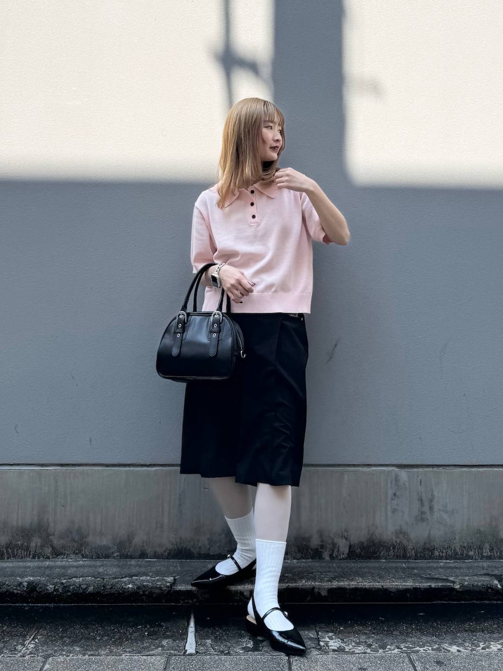 ブラック系のパンプス、ブラック系のスラックス、ブラック系のボストンバッグを着用したレディースの春コーディネートの4枚目の写真