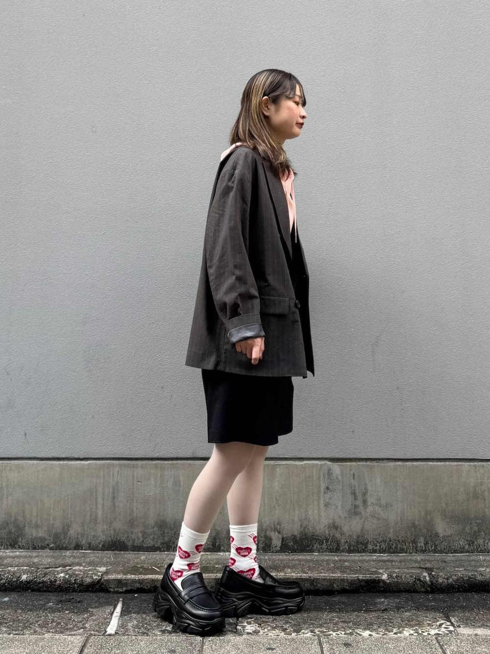 ブラック系のテーラードジャケット、ブラック系のローファー、ブラック系のスラックスを着用したレディースの春コーディネートの7枚目の写真