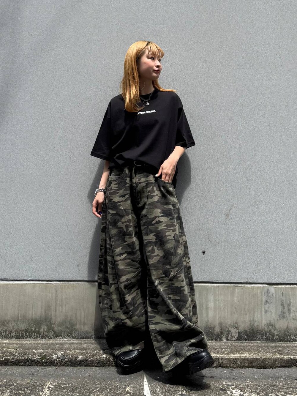ブラック系のローファー、ブラック系のTシャツ/カットソー、グリーン系のデニムパンツを着用したレディースの春コーディネートの2枚目の写真