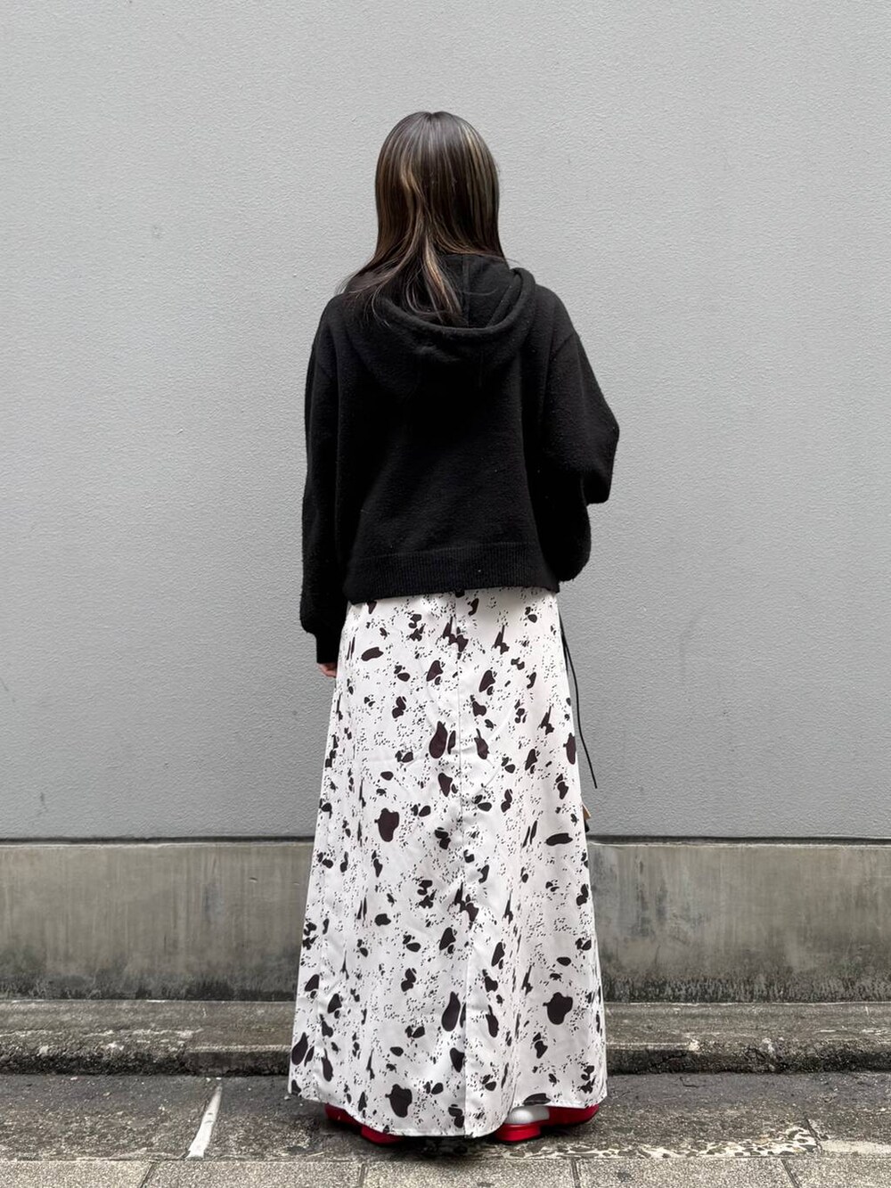 ブラック系のショルダーバッグ、レッド系のパンプス、ブラウン系のスカートを着用したレディースの春コーディネートの6枚目の写真