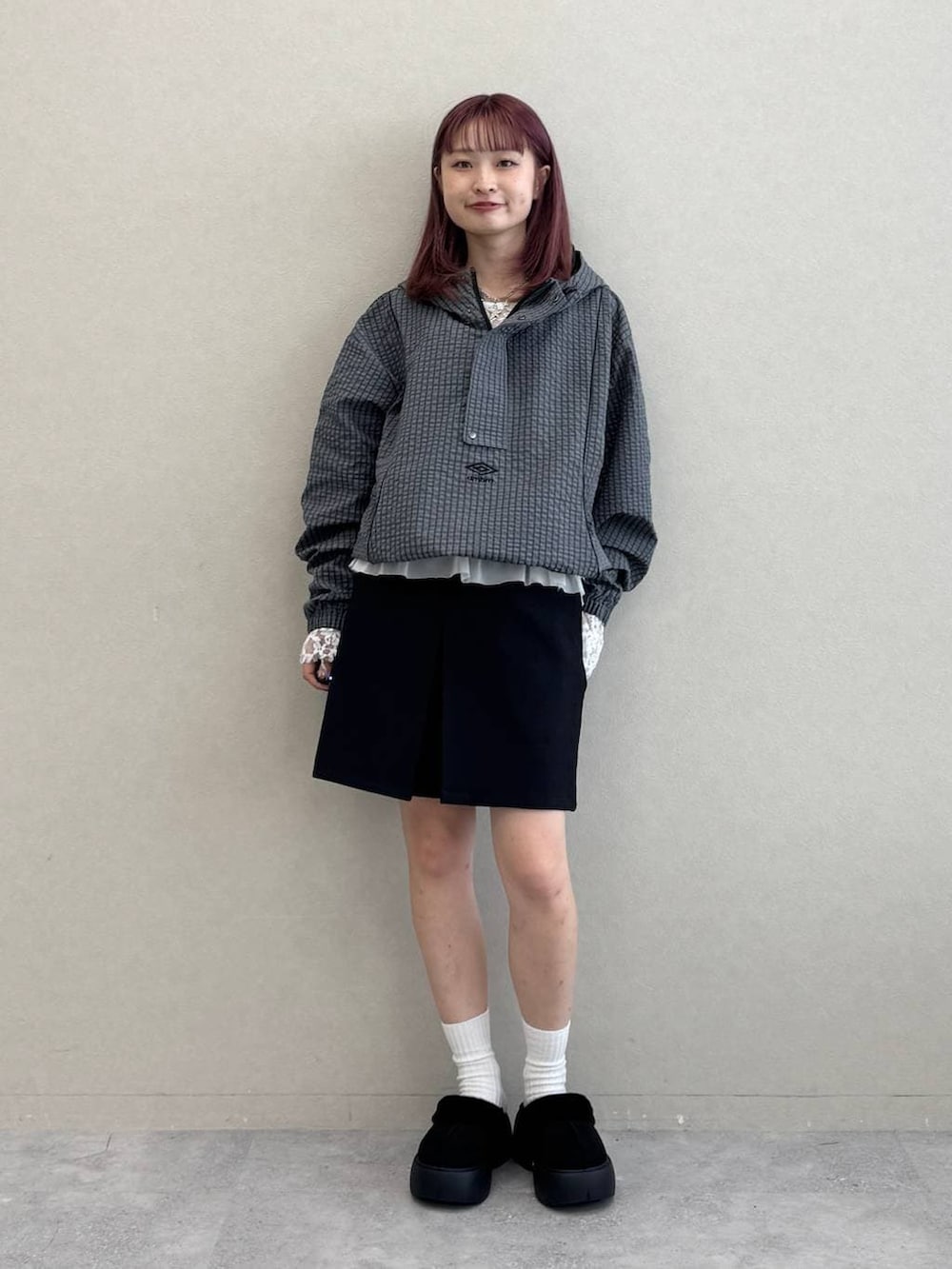 ホワイト系のTシャツ/カットソー、ブラック系のスカート、グレー系のブルゾンを着用したレディースの秋コーディネートの3枚目の写真