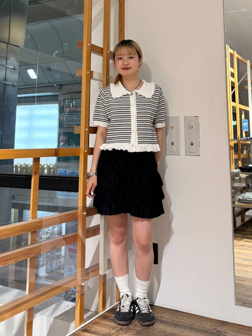 ブラック系のスカート、ホワイト系のカーディガン/ボレロを着用したレディースの夏コーディネートの2枚目の写真