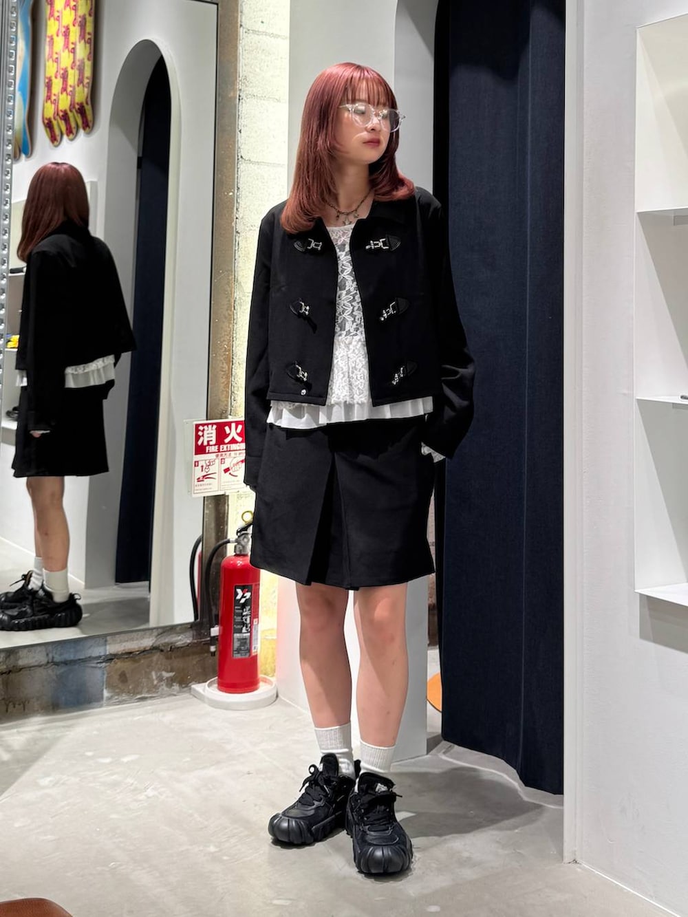 ホワイト系のTシャツ/カットソー、ブラック系のブルゾン、ブラック系のスカートを着用したレディースの秋コーディネートの2枚目の写真