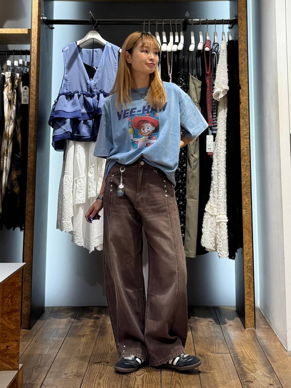 ブルー系のTシャツ/カットソー、ブラウン系のデニムパンツ、その他のキーホルダーを着用したレディースの夏コーディネートの4枚目の写真