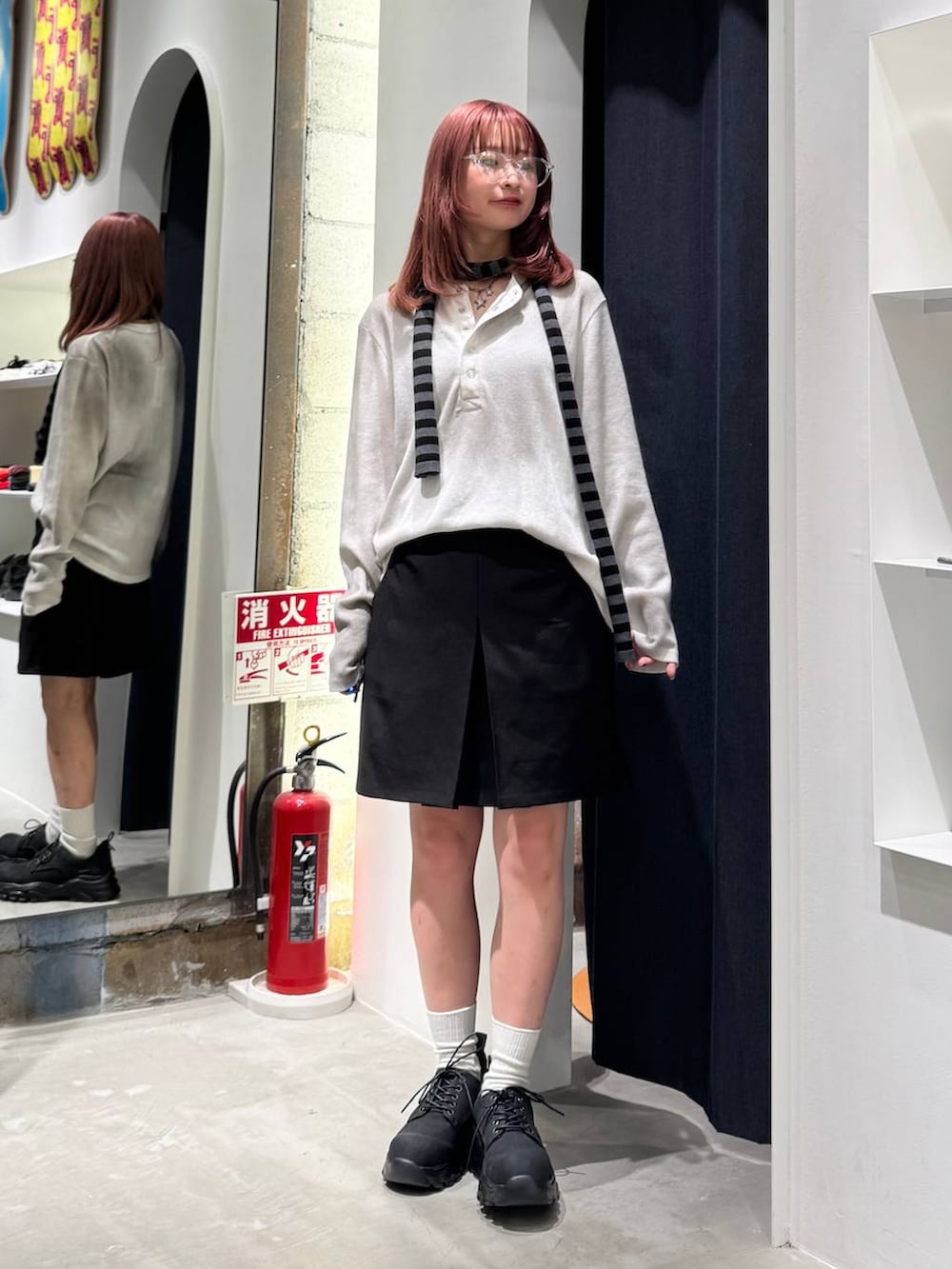 ブラック系のブーツ、ホワイト系のTシャツ/カットソー、ブラック系のニット/セーターを着用したレディースの秋コーディネートの2枚目の写真