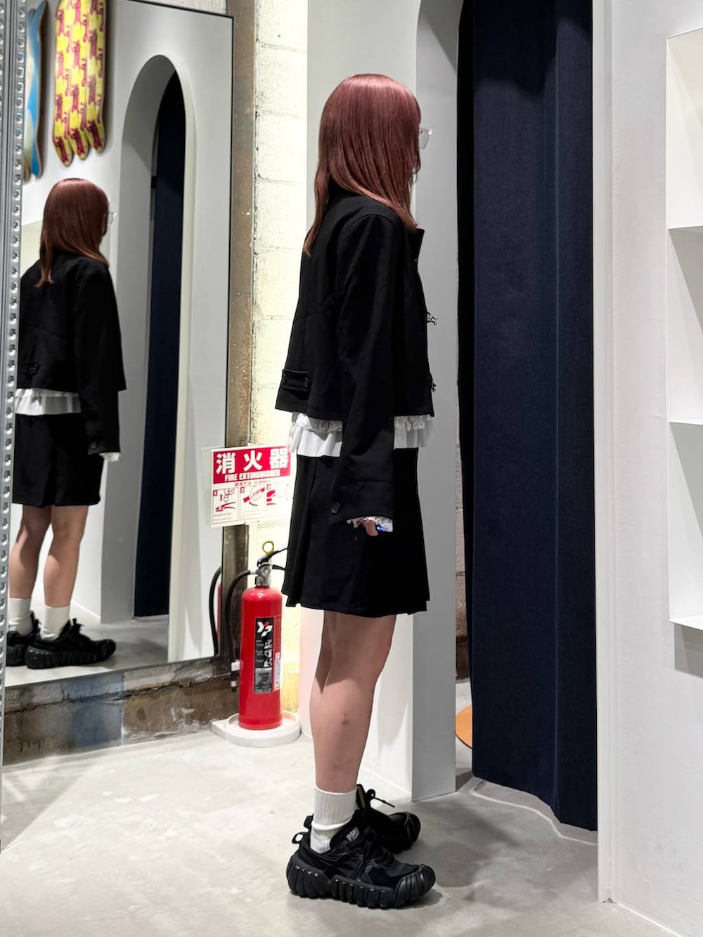 ホワイト系のTシャツ/カットソー、ブラック系のブルゾン、ブラック系のスカートを着用したレディースの秋コーディネートの8枚目の写真