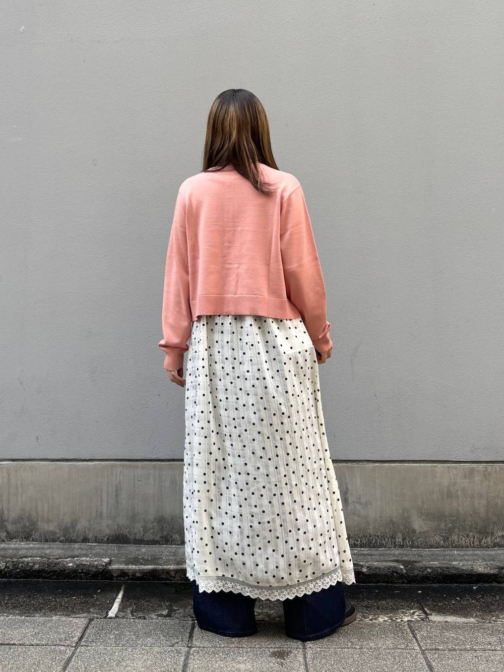 ブルー系のデニムパンツ、ホワイト系のワンピース、ピンク系のTシャツ/カットソーを着用したレディースの春コーディネートの5枚目の写真