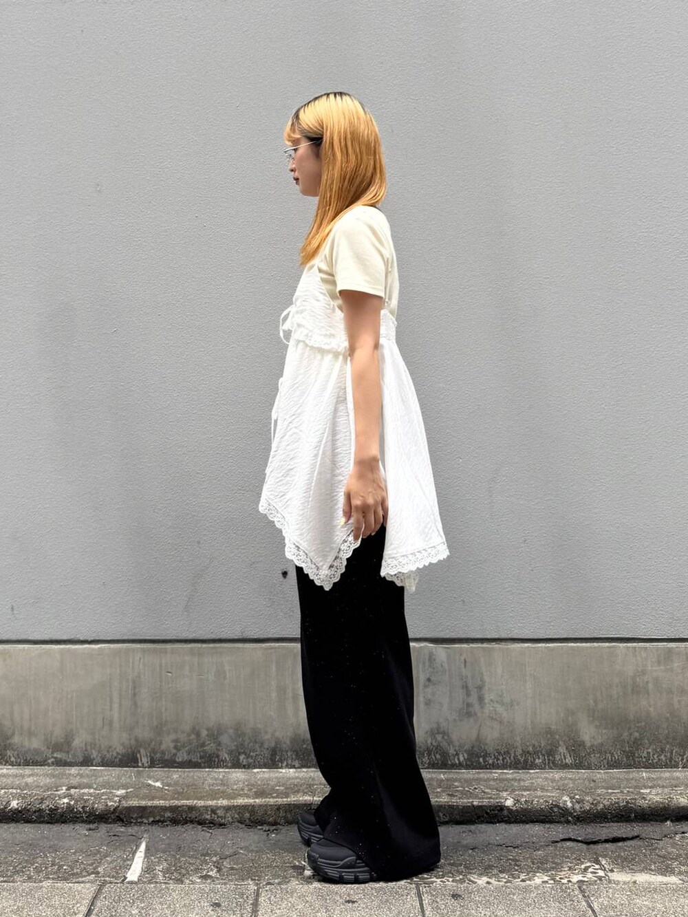ブラック系のサンダル、ブラック系のスウェットパンツ、ホワイト系のTシャツ/カットソーを着用したレディースの夏コーディネートの4枚目の写真
