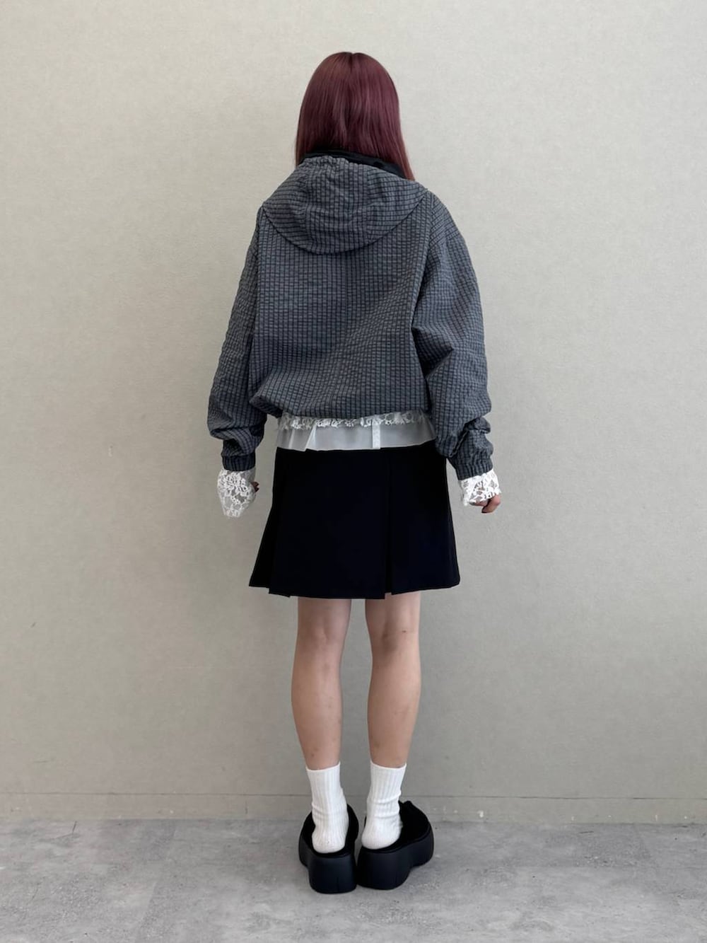 ホワイト系のTシャツ/カットソー、ブラック系のスカート、グレー系のブルゾンを着用したレディースの秋コーディネートの6枚目の写真