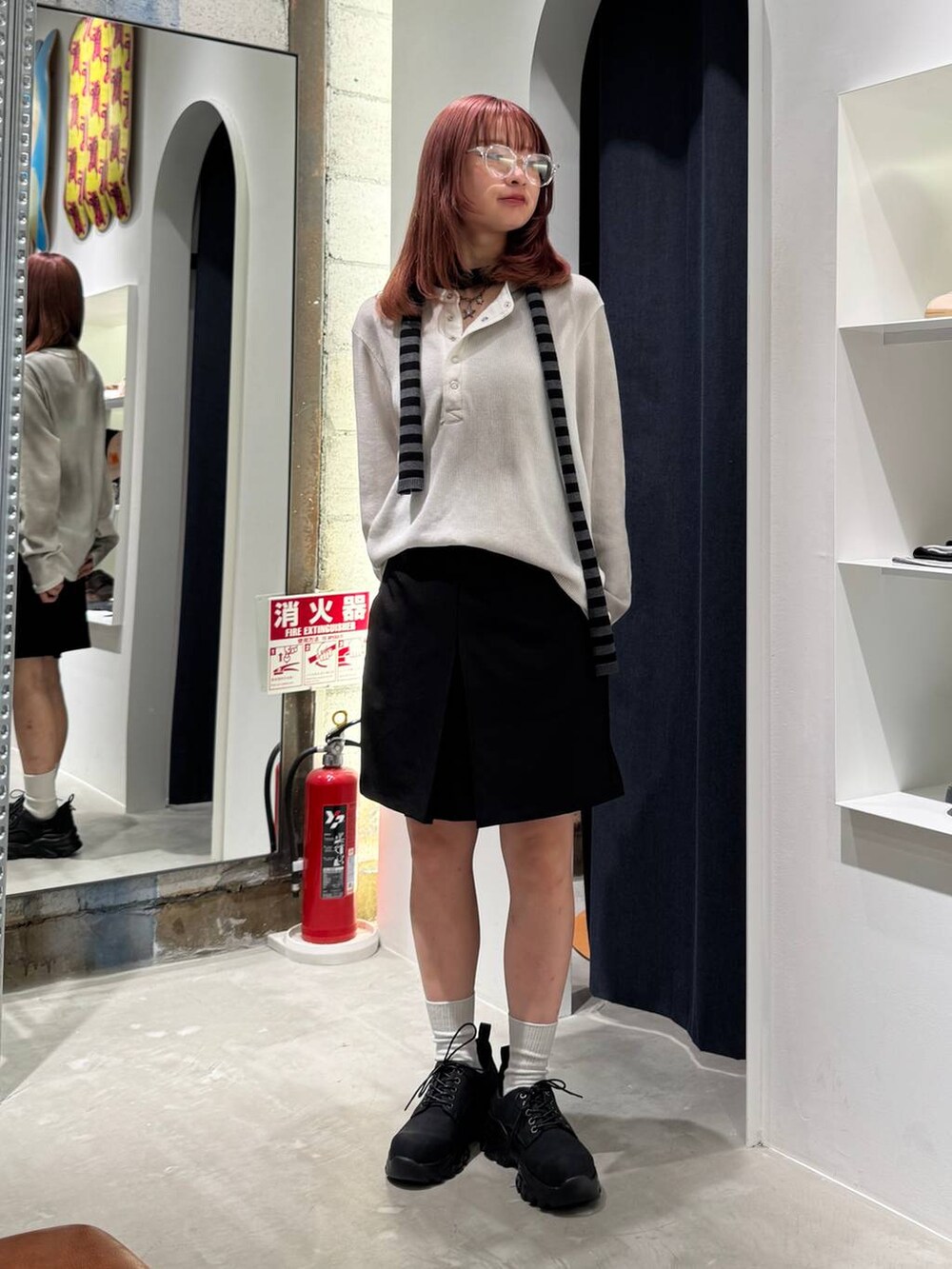 ブラック系のブーツ、ホワイト系のTシャツ/カットソー、ブラック系のニット/セーターを着用したレディースの秋コーディネートの3枚目の写真