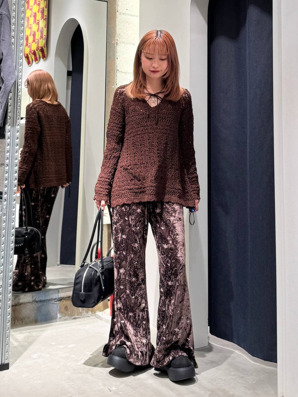 ブラウン系のその他パンツ、ブラック系のブーツ、ブラック系のショルダーバッグを着用したレディースの秋コーディネートの4枚目の写真