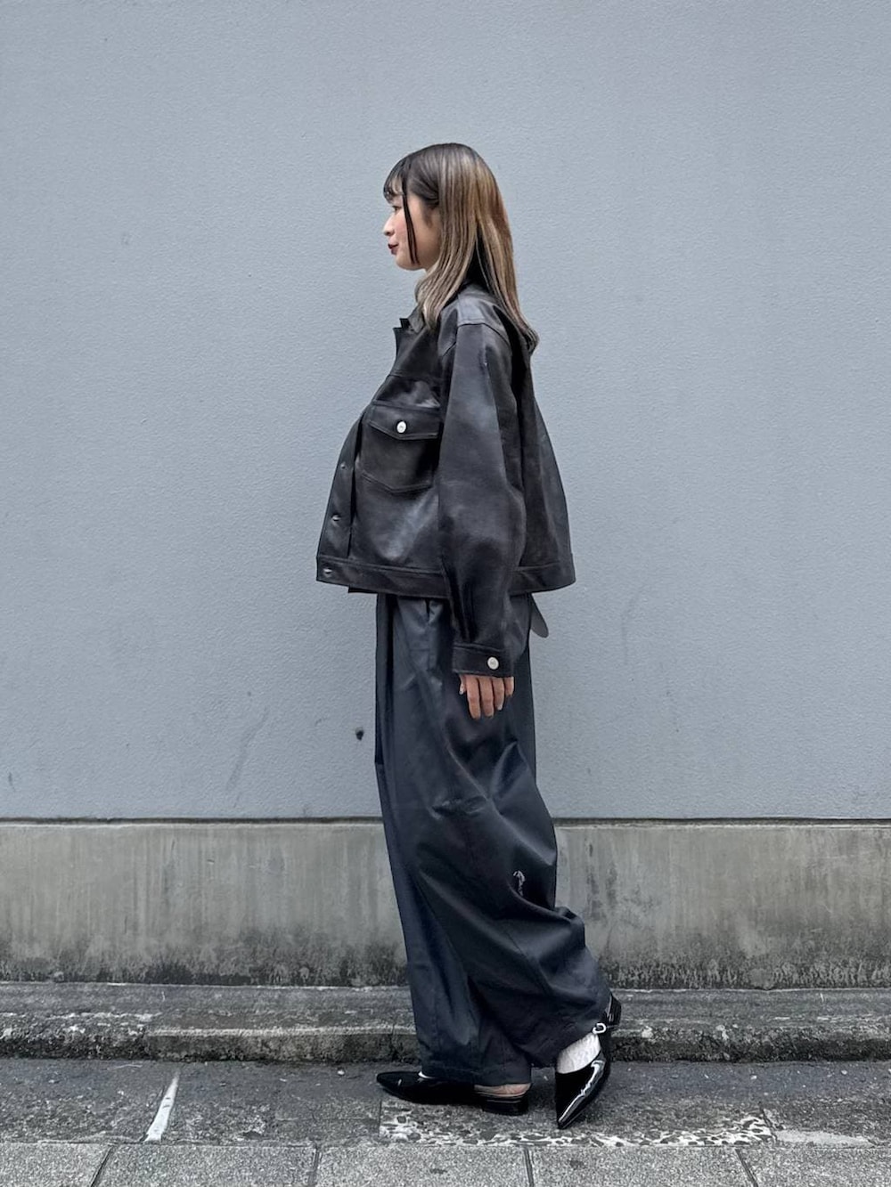 グレー系のチノパンツ、レッド系のパンプス、ブラウン系のブルゾンを着用したレディースの春コーディネートの6枚目の写真