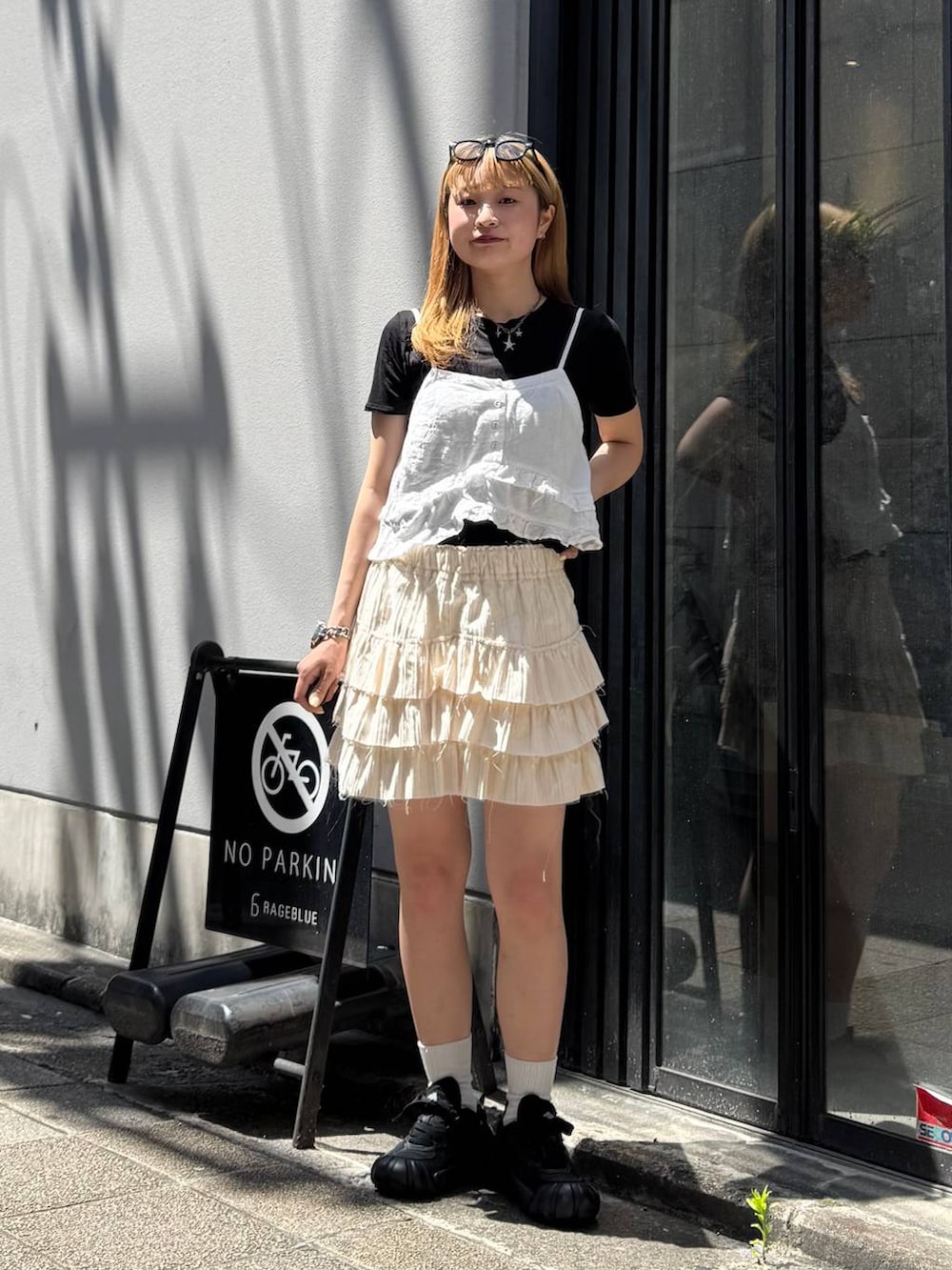 ブラック系のTシャツ/カットソー、ホワイト系のキャミソール、ホワイト系のスカートを着用したレディースの夏コーディネートの3枚目の写真