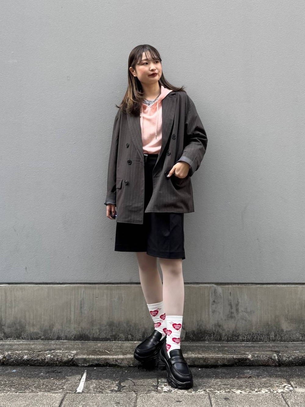 ブラック系のテーラードジャケット、ブラック系のローファー、ブラック系のスラックスを着用したレディースの春コーディネートの3枚目の写真