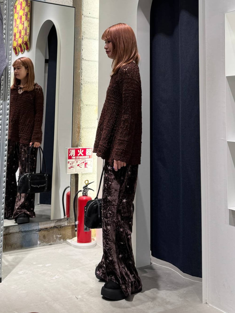 ブラウン系のその他パンツ、ブラック系のブーツ、ブラック系のショルダーバッグを着用したレディースの秋コーディネートの5枚目の写真